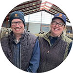 Lyudmyla och Erik Pettersson står i ett stall och ler. De driver Lilla Bankestad. 