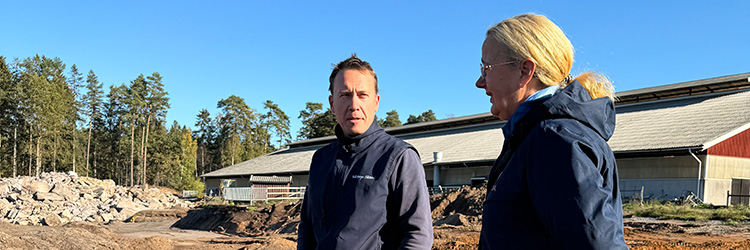 Johan Ocklind, mjölkföretagare på Kårtorp Säteri AB och Anna Johansson, miljörådgivare på Växa. Foto: Maria Nyberg/Växa Två personer pratar utomhus, blå himmel, tallskog, sten